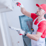 A drywalling installer works on a commercial construction project