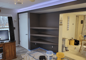 The third step in drywalling instructor Clark Causely's home project creating an alcove for his living room. The three shelves have been primed and painted.