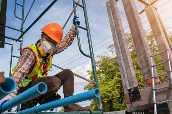 A construction professional working on scaffolding is taking the proper measures to protect himself against a fall injury.